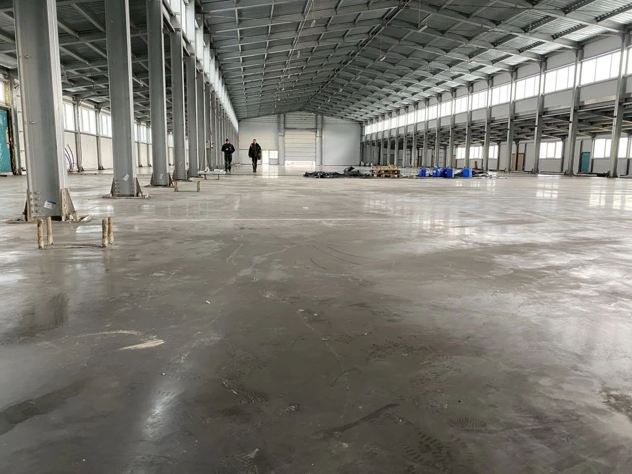 Готовый ровный наливной бетонный пол в складе с рядам техники