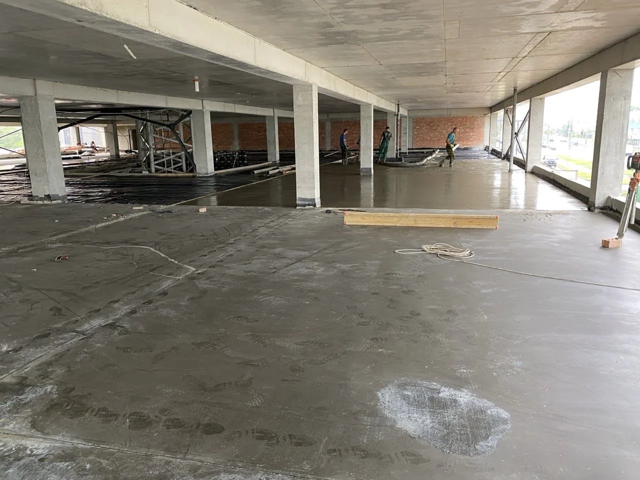 Процесс заливки наливного бетонного пола с армированием на складе